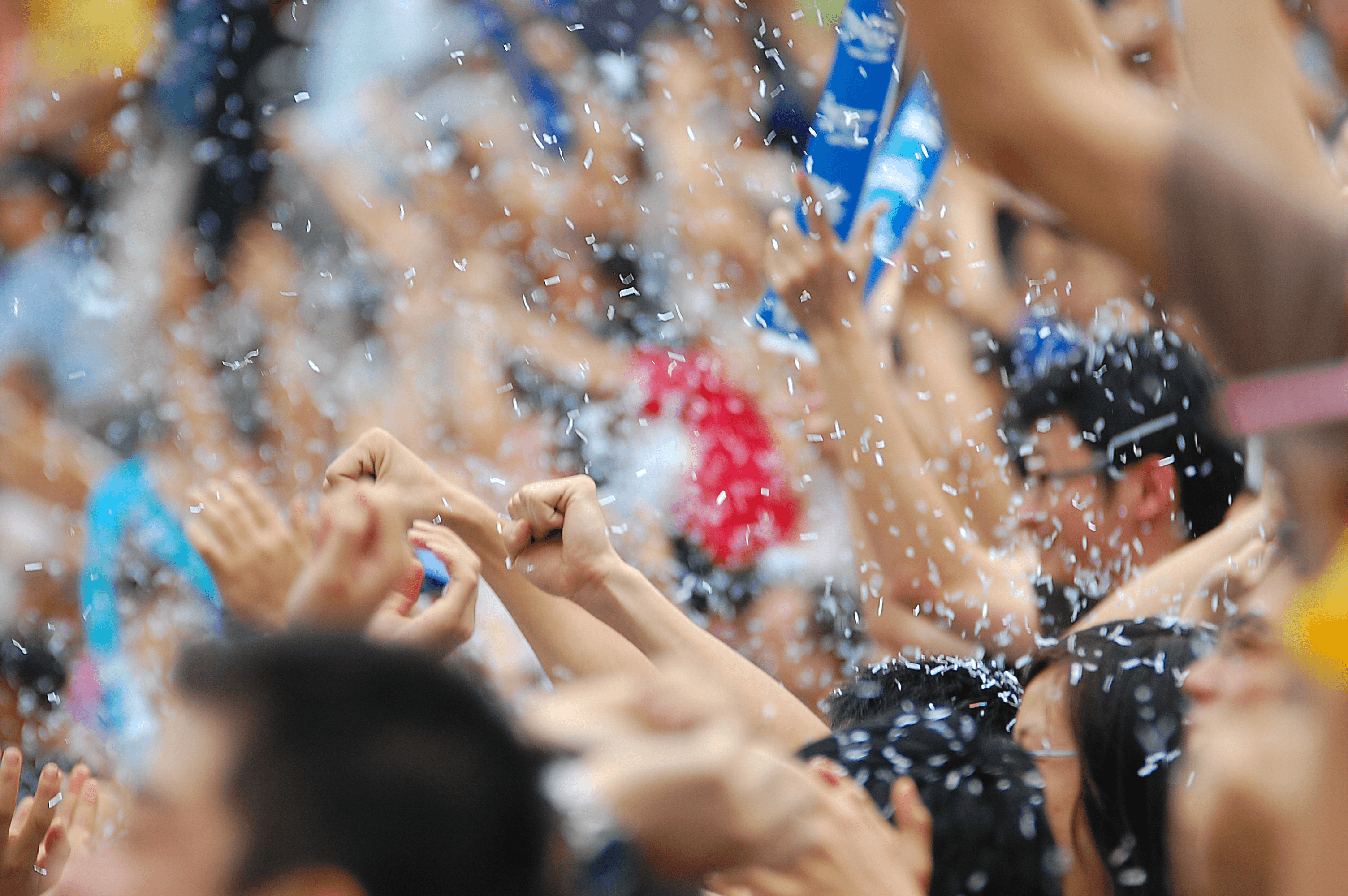 Black and gray image of people celebrating victory with their hands in the air